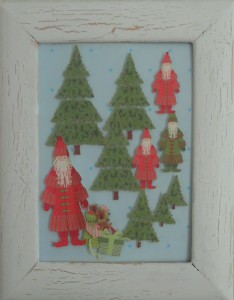 Julebillede, collage lavet af papir og indrammet. Julemænd på vandring i en granskov
